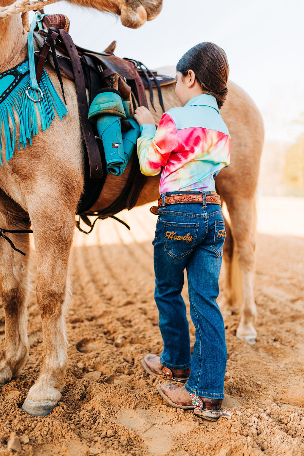Youth in western wear with horse, ranch lifestyle